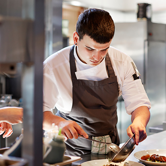 Restaurant staff preparing dishes in back of house