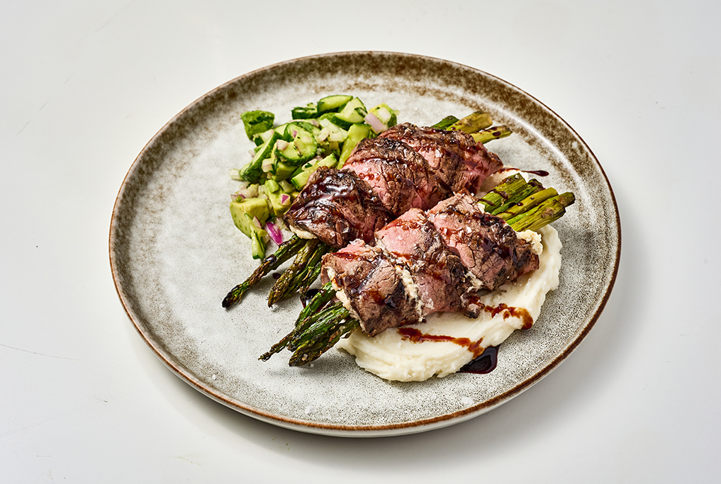 Asparagus and Herbed Cheese Stuffed Flank Steak Rolls on Creamy Mashed Potatoes