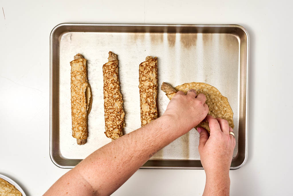 Rolled crepes on a baking sheet