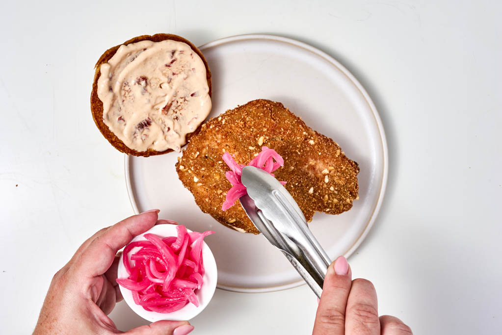 Topping chicken with pickled red onions