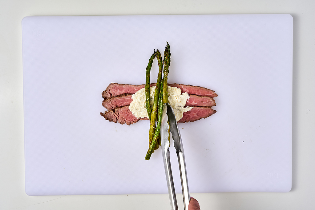 Placing asparagus on flank steak