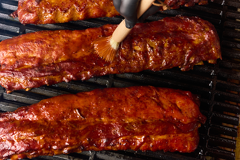 Austin Blues Revamped Rips on a grill, brushed with barbecue sauce