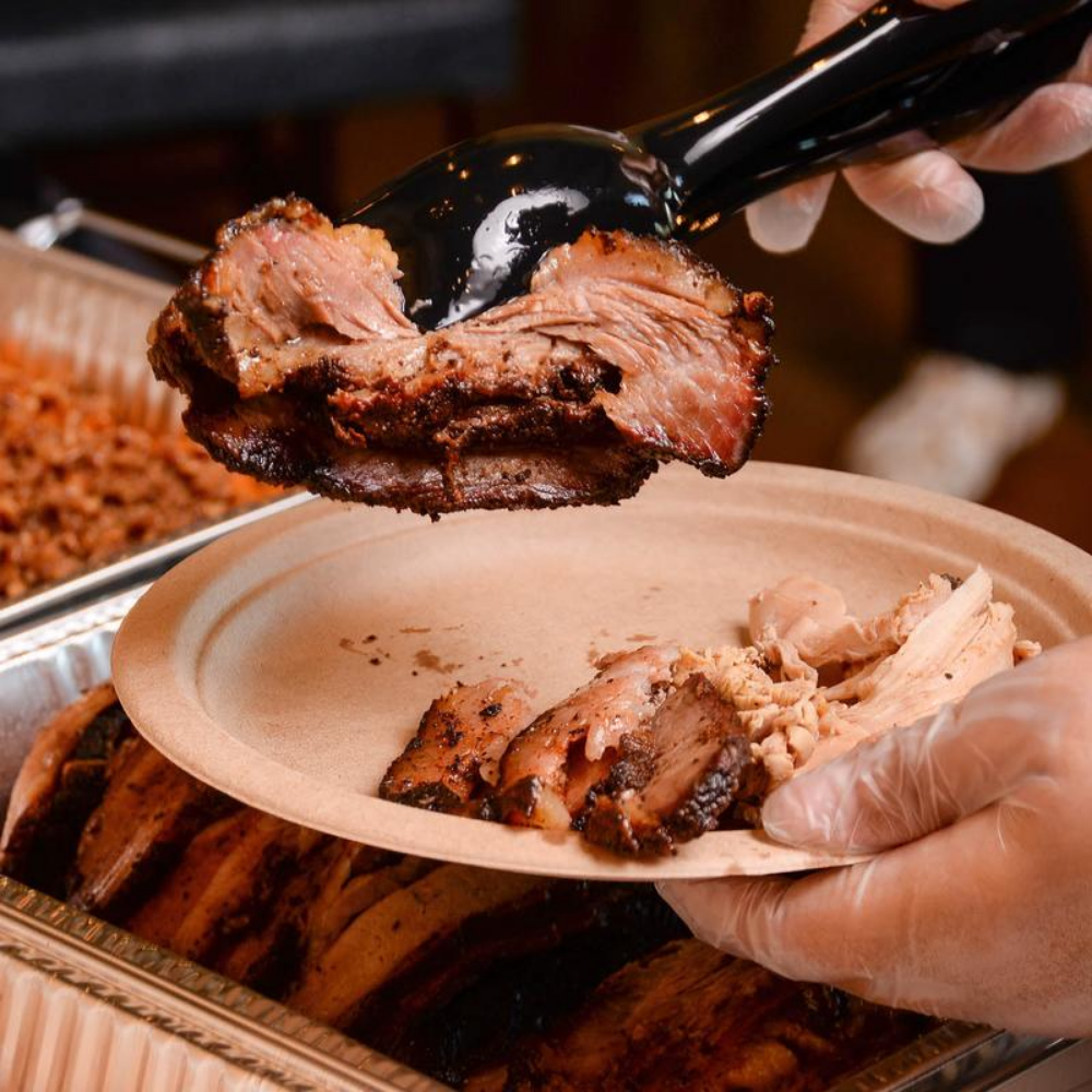 Using tongs to place meat on a plate